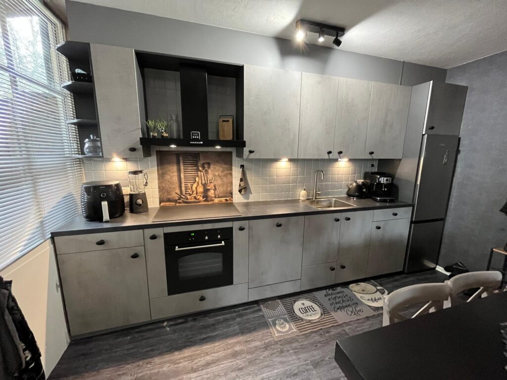 Industriële keukenrenovatie in Nunspeet met betonlook fronten en zwart aanrechtblad