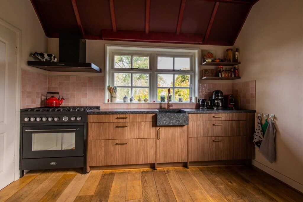 Landelijke keuken op maat in Voorst, met houten fronten en natuurstenen werkblad, ontworpen door Yngwie Stel Keukens.